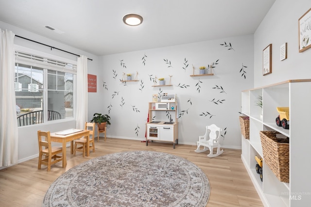 interior space featuring visible vents, light wood-style floors, and baseboards