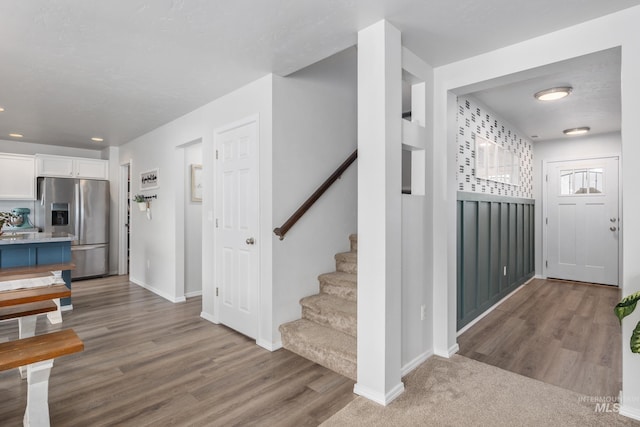 staircase with recessed lighting, wood finished floors, and baseboards