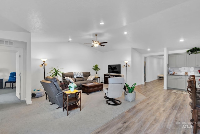 living room featuring visible vents, recessed lighting, ceiling fan, vaulted ceiling, and light wood-type flooring