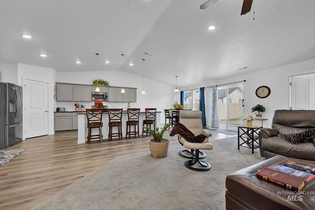 living room with ceiling fan, light wood-style flooring, recessed lighting, and vaulted ceiling