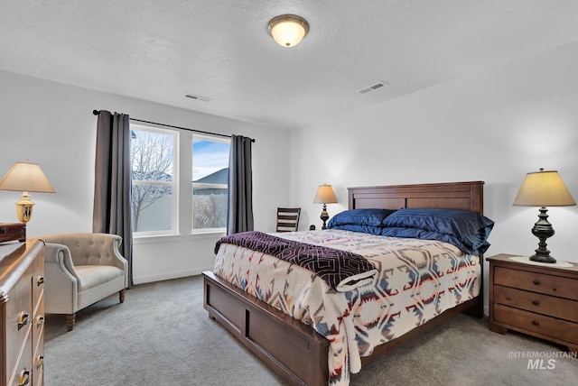 carpeted bedroom with baseboards, visible vents, and a textured ceiling