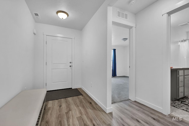 foyer entrance featuring visible vents and wood finished floors