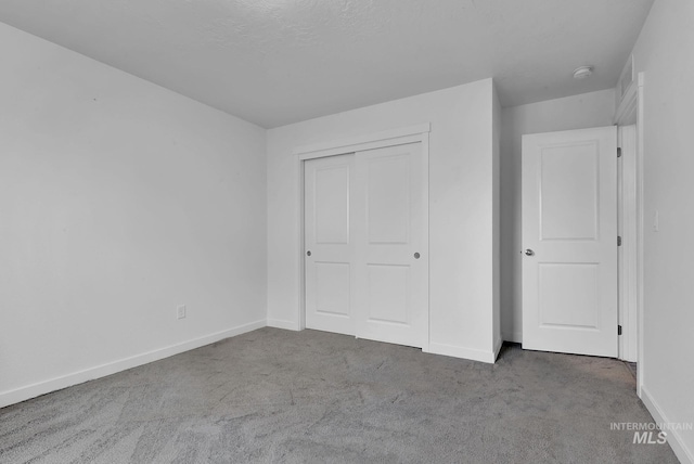 unfurnished bedroom featuring a closet, baseboards, and carpet floors