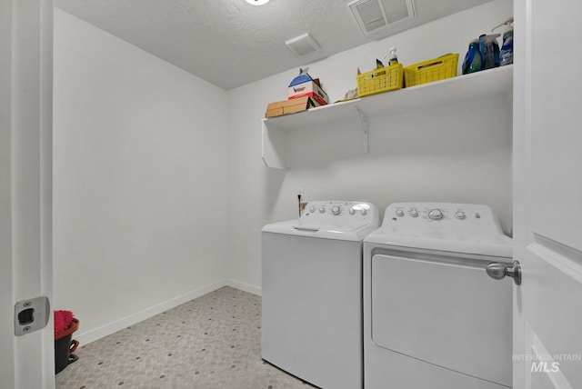 washroom featuring light floors, visible vents, baseboards, laundry area, and separate washer and dryer