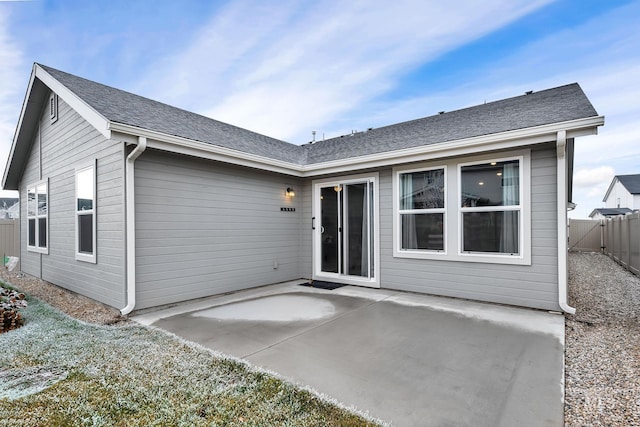 back of house featuring a shingled roof, a patio, and fence