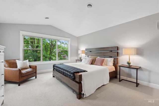 bedroom featuring lofted ceiling, light colored carpet, and baseboards