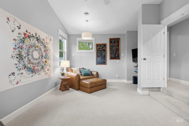 living area featuring carpet, baseboards, ceiling fan, and vaulted ceiling