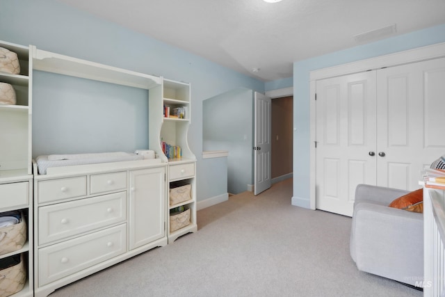 bedroom with light colored carpet, a closet, and baseboards