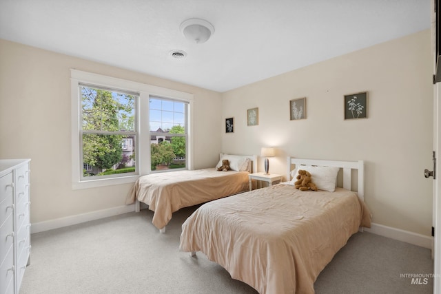 bedroom with baseboards and light colored carpet