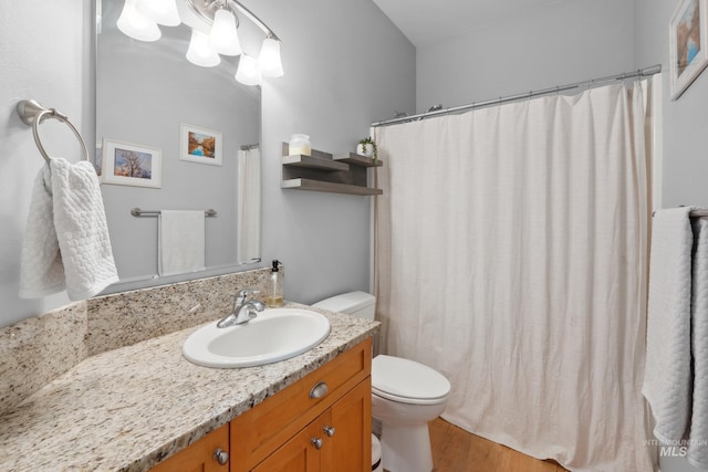 full bath featuring toilet, vanity, wood finished floors, and curtained shower