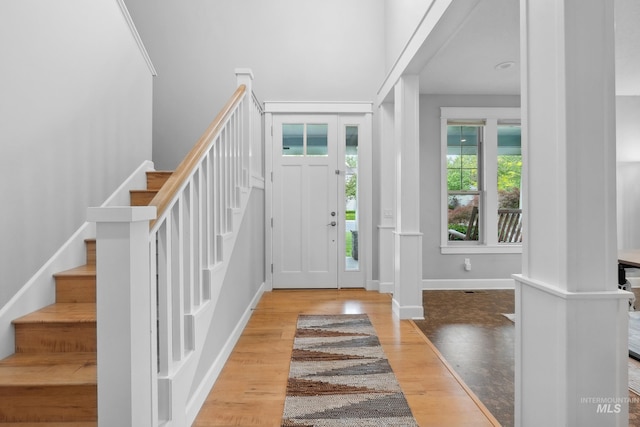entrance foyer with stairway, wood finished floors, and baseboards