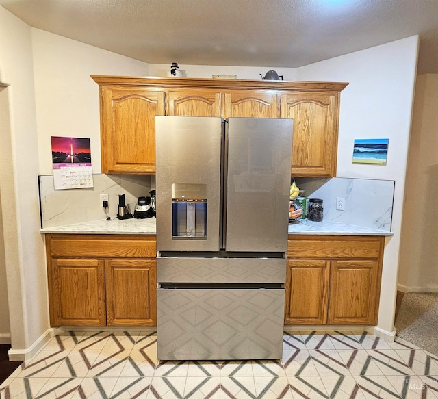 kitchen with stainless steel fridge with ice dispenser, backsplash, light tile patterned floors, and vaulted ceiling