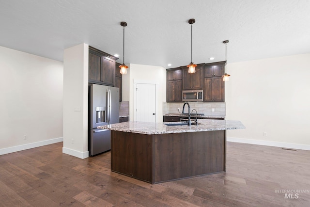 7253 River View Dr, Marsing, ID 83639 - kitchen featuring appliances with stainless steel finishes, dark brown cabinetry, tasteful backsplash, dark wood-type flooring, and recessed lighting