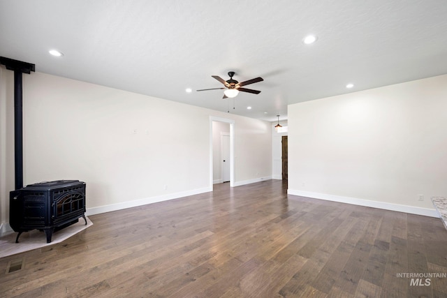 7253 River View Dr, Marsing, ID 83639 - empty room featuring a wood stove, ceiling fan, recessed lighting, and dark wood finished floors