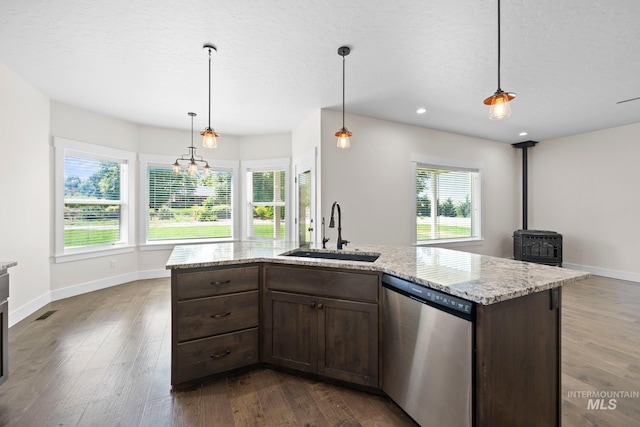 7253 River View Dr, Marsing, ID 83639 - kitchen with dishwasher, a wood stove, dark wood finished floors, dark brown cabinets, and light stone countertops