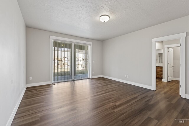 unfurnished room featuring baseboards, a textured ceiling, and dark wood-style floors