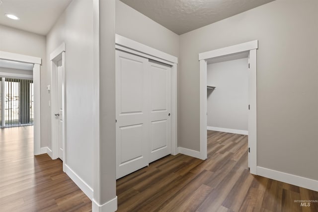 hallway featuring recessed lighting, baseboards, and dark wood finished floors