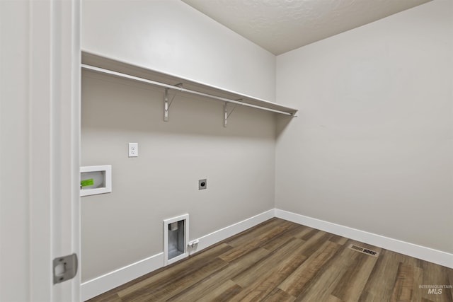 clothes washing area featuring visible vents, laundry area, dark wood-style flooring, electric dryer hookup, and washer hookup