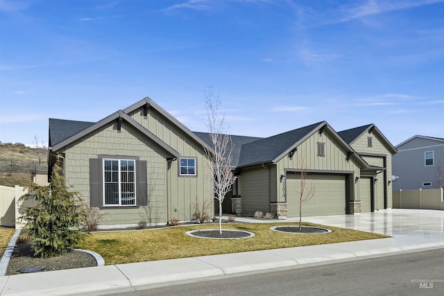 view of front of property featuring a front yard, fence, board and batten siding, and driveway