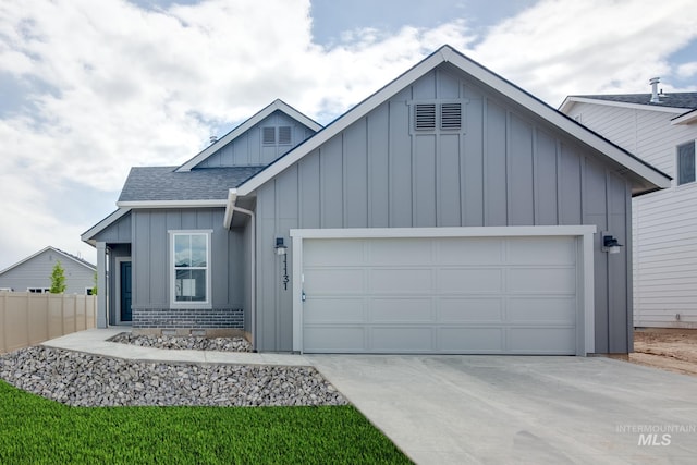 view of front of property featuring a garage, a shingled roof, fence, concrete driveway, and board and batten siding