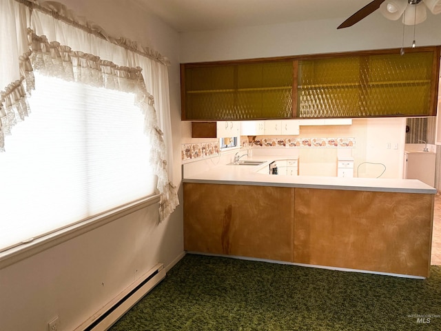 kitchen featuring carpet flooring, baseboard heating, ceiling fan, and a sink