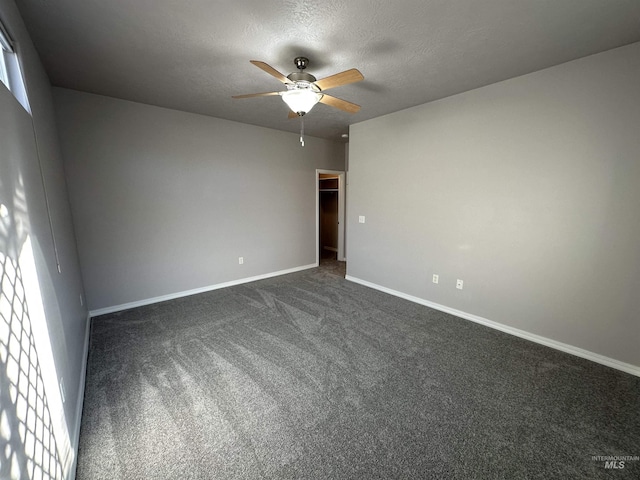 unfurnished room featuring a textured ceiling, dark colored carpet, and ceiling fan