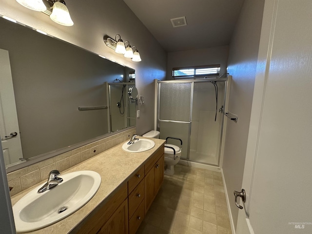 bathroom with toilet, vanity, backsplash, and a shower with door