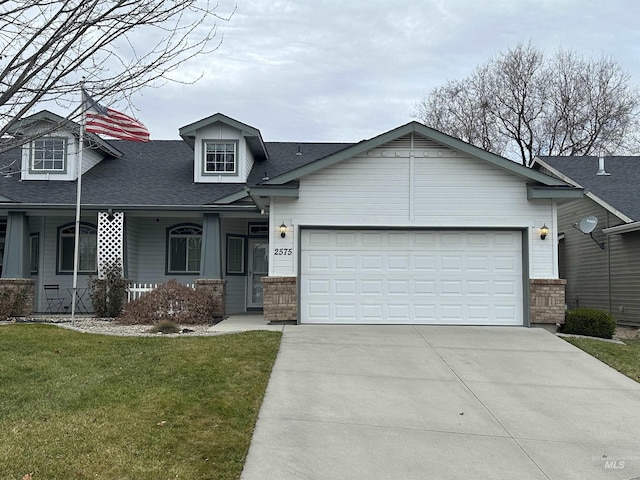 view of front of property featuring a front lawn, a porch, and a garage