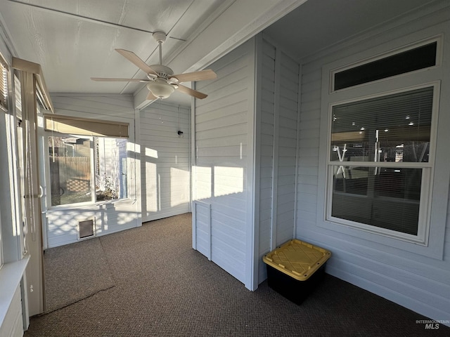 unfurnished sunroom with ceiling fan and vaulted ceiling