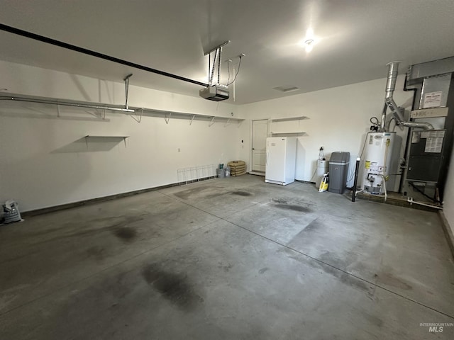 garage with heating unit, gas water heater, white fridge, and a garage door opener