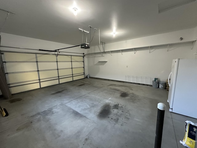 garage featuring a garage door opener and white refrigerator