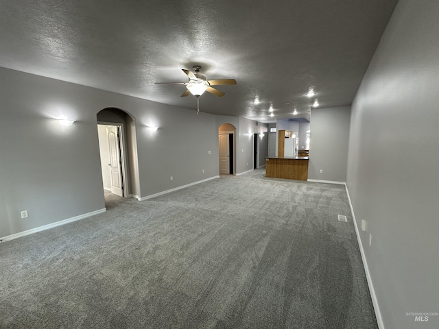 unfurnished living room with ceiling fan, a textured ceiling, and carpet flooring