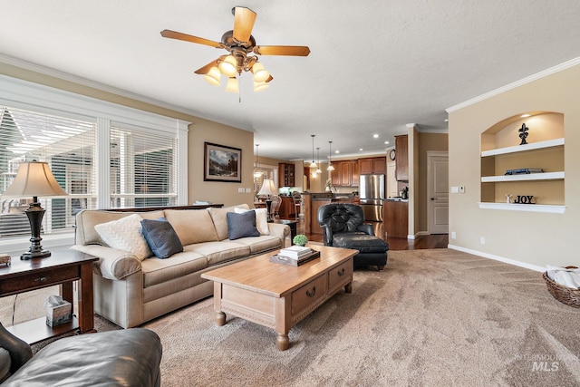 living room featuring light colored carpet, a ceiling fan, baseboards, built in features, and ornamental molding