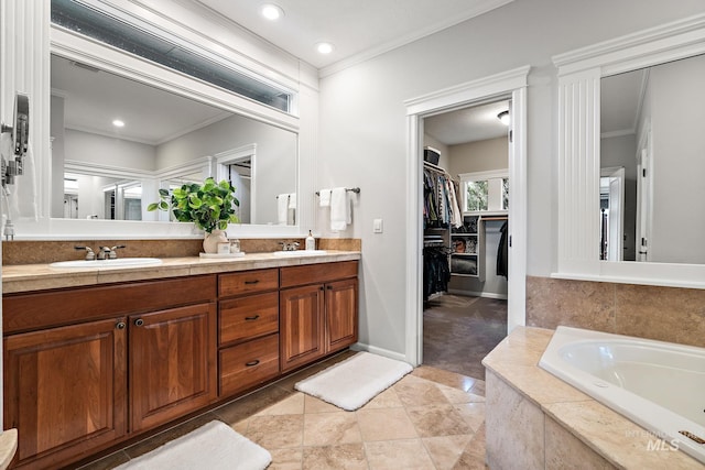 bathroom featuring double vanity, ornamental molding, a sink, and a walk in closet