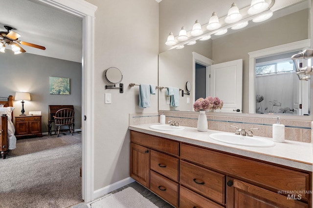 bathroom featuring double vanity, baseboards, a ceiling fan, and a sink