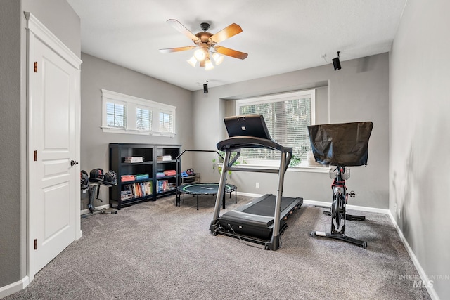 workout area featuring carpet floors, ceiling fan, and baseboards