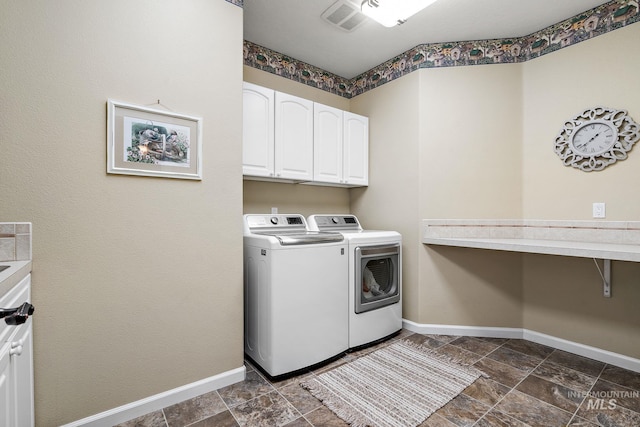 laundry room with washer and clothes dryer, visible vents, cabinet space, stone finish flooring, and baseboards