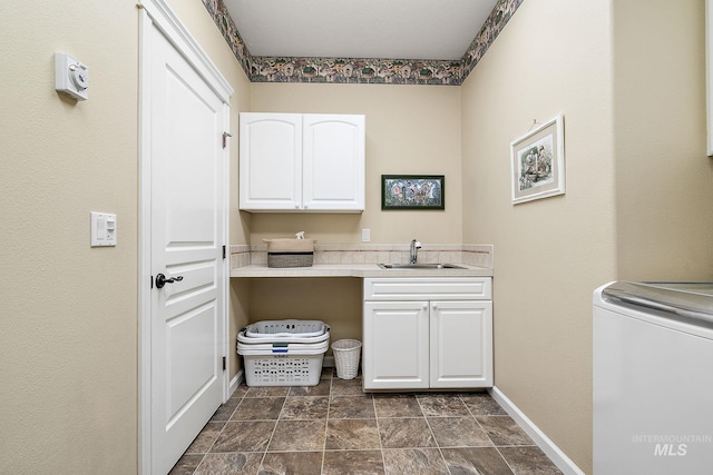 laundry area with washer / dryer, cabinet space, a sink, and baseboards