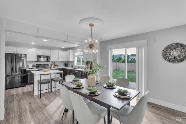 5467 N Claret Cup Way, Meridian, ID 83646 - dining room with light wood-style flooring, a chandelier, baseboards, and recessed lighting