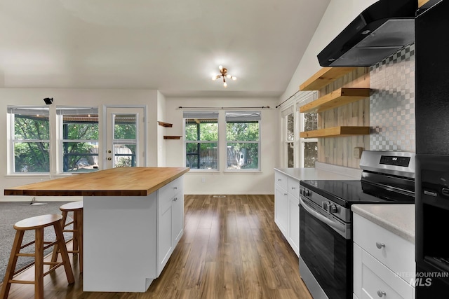 321 S Powerline Rd, Nampa, ID 83686 - kitchen featuring open shelves, stainless steel range with electric cooktop, butcher block countertops, wall chimney range hood, and white cabinets