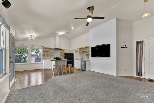 321 S Powerline Rd, Nampa, ID 83686 - unfurnished living room with vaulted ceiling, ceiling fan, wood finished floors, and carpet