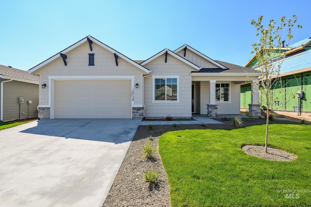 craftsman-style house with driveway, a shingled roof, stone siding, an attached garage, and a front yard