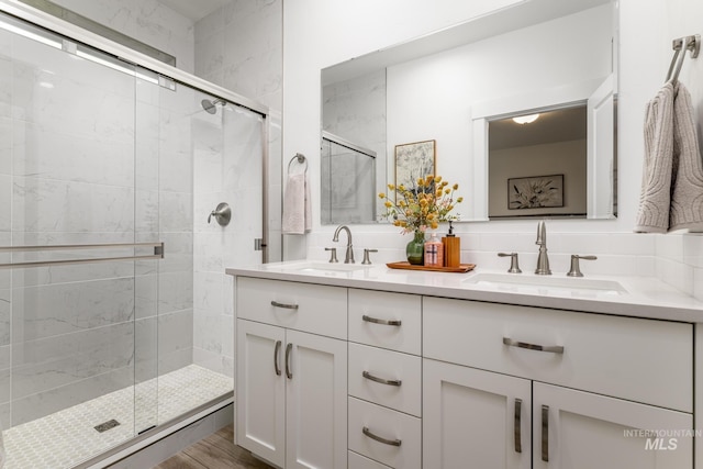 full bathroom with tasteful backsplash, a sink, and a shower stall