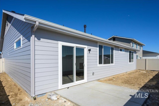 rear view of house with a patio area and fence