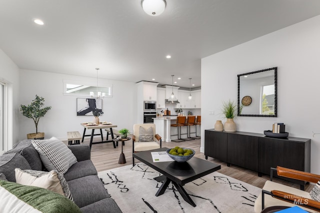 living room featuring a notable chandelier and light wood-type flooring