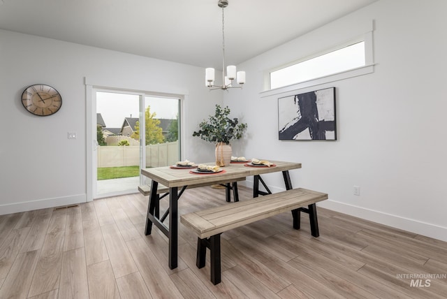 dining area with light wood-type flooring, a healthy amount of sunlight, and baseboards