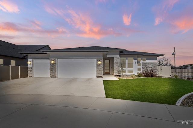 prairie-style house featuring a lawn and a garage