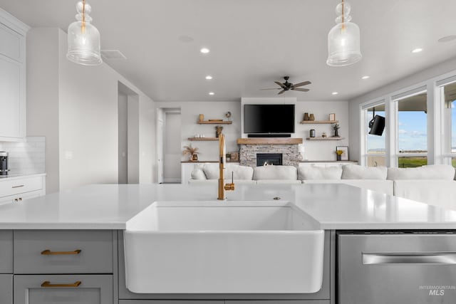 kitchen featuring sink, white cabinets, ceiling fan, and hanging light fixtures