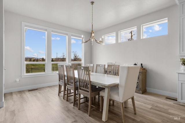 dining space featuring an inviting chandelier and light hardwood / wood-style floors