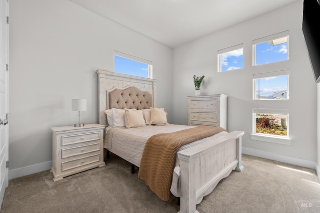 bedroom featuring light carpet and multiple windows